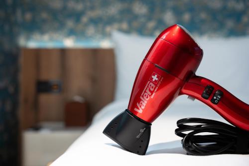 a red blow dryer sitting on top of a bed at 禾淞津別邸 Kashotsu Bettei in Taichung