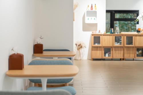 a room with chairs and a table and a cabinet at 禾淞津別邸 Kashotsu Bettei in Taichung