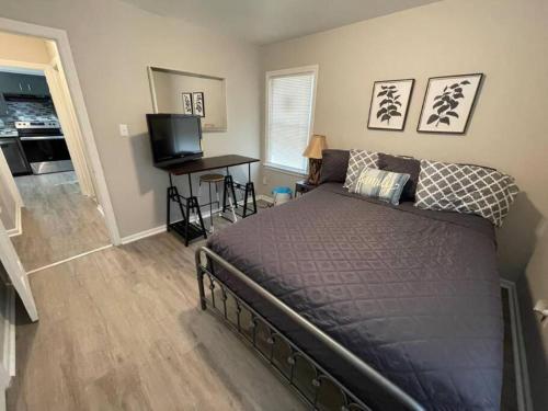 a bedroom with a bed and a desk and a television at Relaxing Bungalow in Cleveland