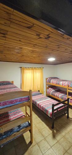 a room with three bunk beds and a window at Matices Hostel Centro in El Calafate
