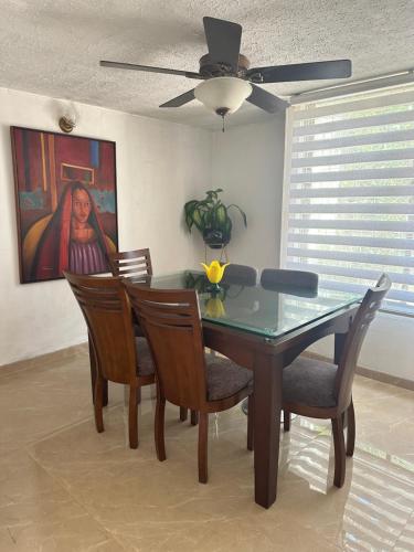 ein Esszimmer mit einem Glastisch und Stühlen in der Unterkunft Casa Los Almendros, Valledupar casa completa in Valledupar