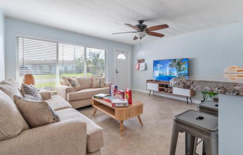 a living room with a couch and a tv at Paradise Oasis with Heated Pool 8 mins from the Beach! in Pompano Beach