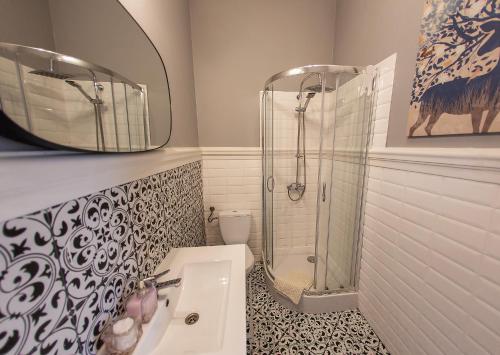 a bathroom with a shower and a sink and a mirror at Apartament u Olechny in Bydgoszcz