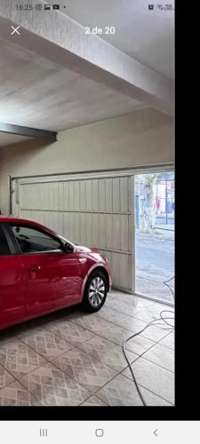 um carro vermelho estacionado dentro de uma garagem em Flat 102 em São Paulo
