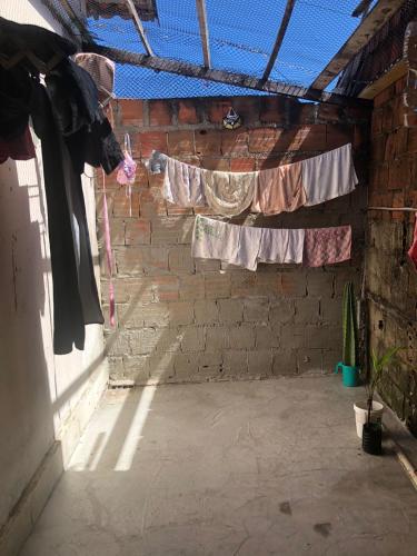 um quarto com uma parede de tijolos com roupa a secar numa linha em Flat 102 em São Paulo