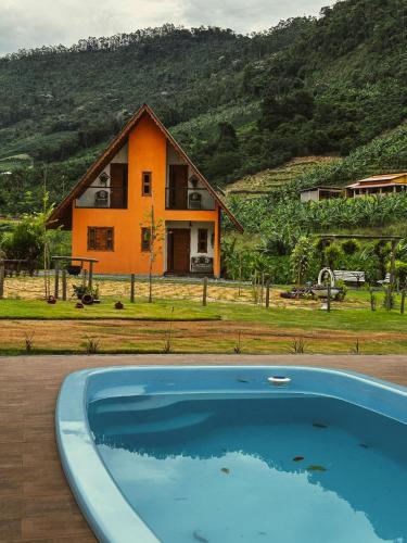 a house with a swimming pool in front of a house at Chalé Casa em Vargem Alta in Vargem Alta