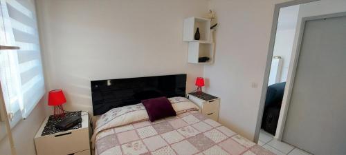 - une petite chambre avec un lit et une cheminée dans l'établissement A deux pas de la mer - Marseillan Plage, à Marseillan