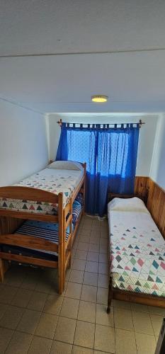 a room with two bunk beds and a window at Matices Hostel Centro in El Calafate