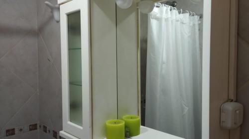 a bathroom with a mirror and a white shower curtain at Córdoba View in Neuquén