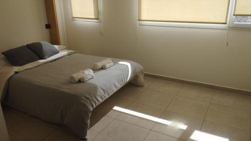 a bedroom with a bed with towels on it at Córdoba View in Neuquén