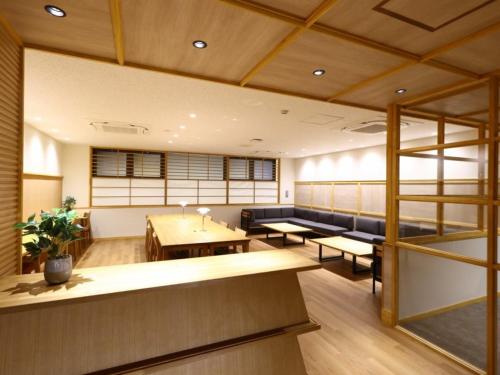 a room with couches and tables in a building at Hotel Yudanaka in Yamanouchi
