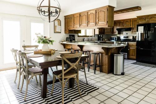 uma cozinha com armários de madeira e uma mesa e cadeiras em PIne Valley Guesthouse 