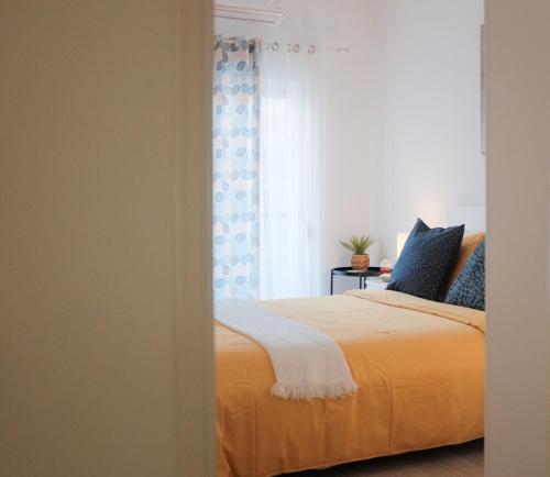 Un dormitorio con una cama amarilla y una ventana en Just4u Apartment, en Almada