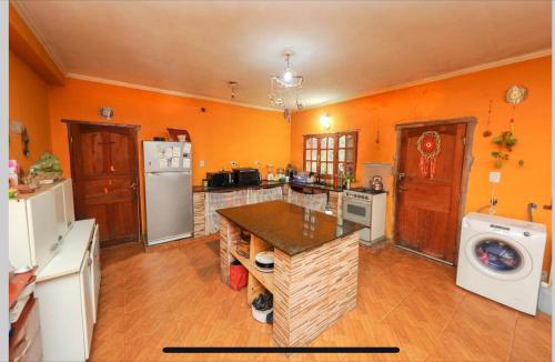 une grande cuisine avec des murs orange et un comptoir dans l'établissement Casita en lozano, à Lozano
