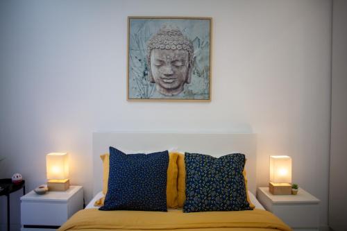 a bedroom with a bed with two lamps and a statue at Just4u Apartment in Almada