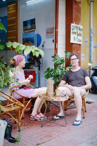a man and woman sitting in chairs on a patio at Sông Suối Homestay in Quy Nhon