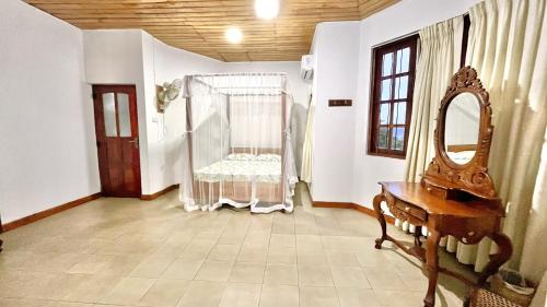 een kamer met een wieg met een spiegel en een kaptafel bij Pearl House in Kandy