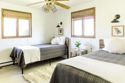um quarto com 2 camas e uma ventoinha de tecto em PIne Valley Guesthouse 