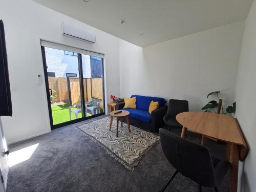 a living room with a blue couch and a table at Modern Loft in Christchurch CBD with Private Courtyard in Christchurch