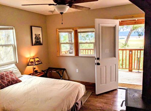 een slaapkamer met een bed en een deur met een veranda bij #3 Howling Wolf's Lair - Cabin W/Fireplace & Views in Santa Ysabel