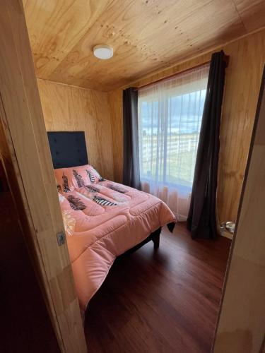 - une chambre avec un lit rose et une fenêtre dans l'établissement Quilquico spa, à Quilquico