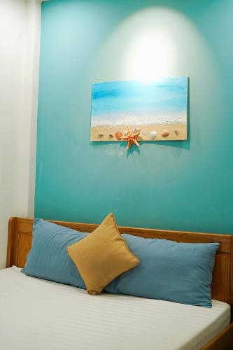 a bedroom with a bed with a picture of a beach at Sông Suối Homestay in Quy Nhon
