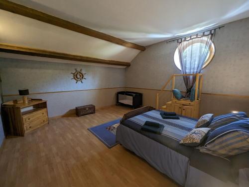 a bedroom with a large bed and a window at Gîte familial 2 chambres avec piscine, animaux, et vaste terrain à Forcey - FR-1-611-75 in Forcey