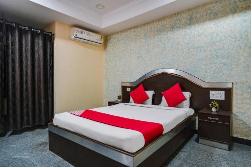 a bedroom with a bed with red pillows at Grand Aarvi inn in Hyderabad