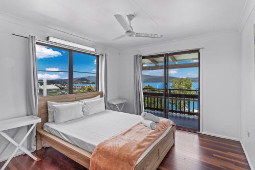 a bedroom with a bed and a large window at Sailor's Lookout in Airlie Beach