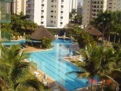 una grande piscina con palme e edifici di Cond. Clube Riviera S. Lourenço a Bertioga