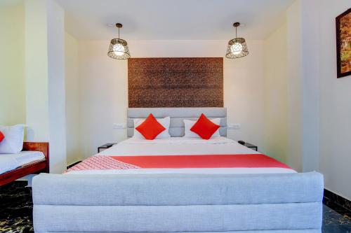 een slaapkamer met een groot bed met rode kussens bij OYO Flagship P S Grand in Port Blair