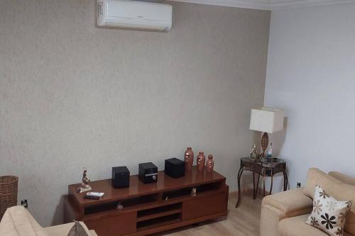 a living room with a couch and a table at Casa completa com área de lazer próxima ao centro shopping e principais vias de acesso!! in Araraquara
