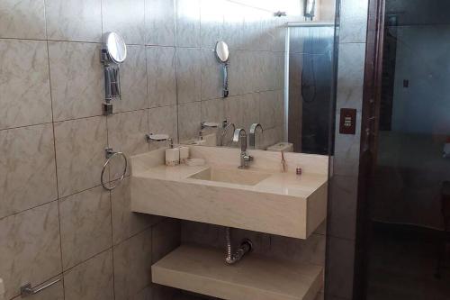 a bathroom with a sink and a mirror at Casa/Sobrado em Araraquara-SP in Araraquara