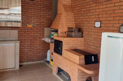 a kitchen with a brick wall and a stove at Casa completa com área de lazer próxima ao centro shopping e principais vias de acesso!! in Araraquara