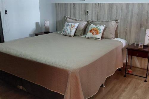 a bedroom with a large bed with pillows on it at Casa completa com área de lazer próxima ao centro shopping e principais vias de acesso!! in Araraquara