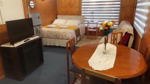 a bedroom with a table and a bed and a television at Depto. Altos de Tenglo in Puerto Montt