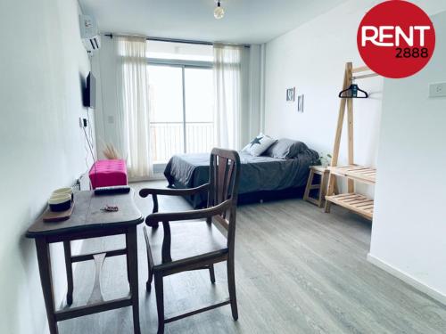 a room with a desk and a bed and a table at Rent Balbin in Buenos Aires