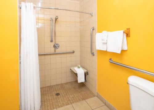 y baño con ducha, aseo y toallas. en Rodeway Inn Fallbrook Downtown, en Fallbrook