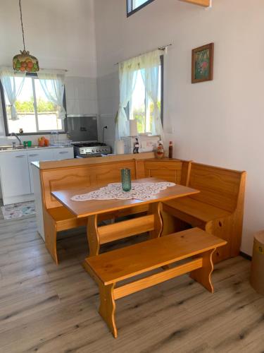 a kitchen with a table and benches in it at Cabaña Raihuè Austral in Puerto Montt
