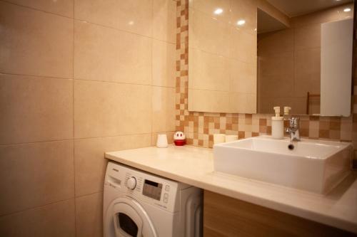 Un baño con lavabo y lavadora. en Just4u Apartment 2, en Almada