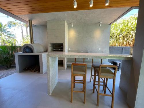 eine Außenküche mit großer Theke und Hockern in der Unterkunft Casa Maçunim 2 in Pôrto de Pedras