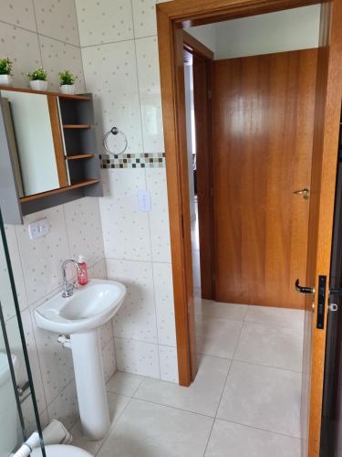 a bathroom with a sink and a mirror at Ap 03 edificio Sao Paulo I in Ponta Grossa