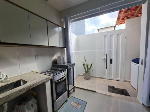 a kitchen with a sink and a stove top oven at Apt C com 2 quarto com ar e garagem in Montes Claros