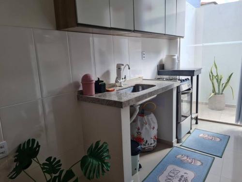 a kitchen with a sink and a counter with two rugs at Apt C com 2 quarto com ar e garagem in Montes Claros