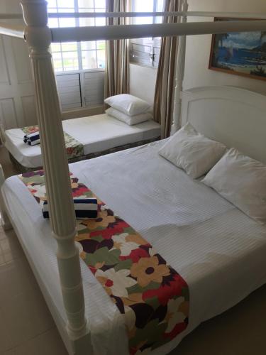 1 Schlafzimmer mit 2 Betten und einem Himmelbett in der Unterkunft New Mavida Lodge in Levuka