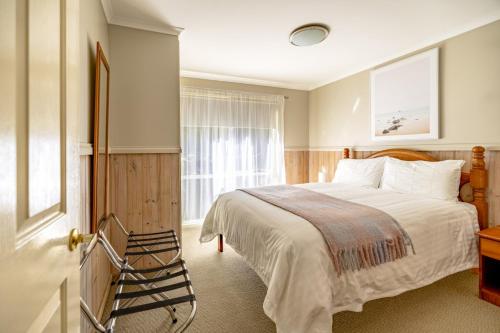 ein Schlafzimmer mit einem großen Bett und einem Fenster in der Unterkunft The Crays Accommodation in Strahan