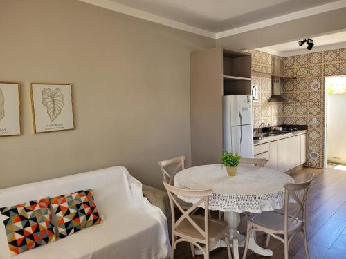 sala de estar con sofá blanco y mesa en Excelente Sobrado Confortável no Centro de Tijucas Próximo as Praias, en Tijucas