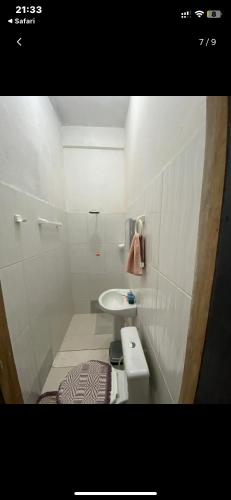 a white bathroom with a sink and a toilet at Hotel Divino in Caissara