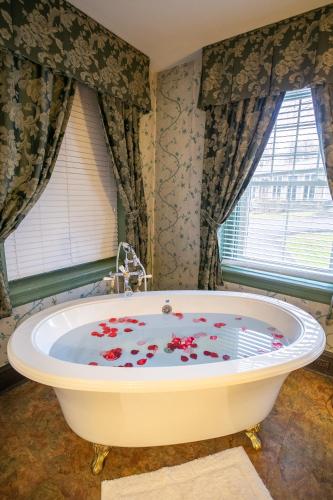 a bath tub with red flowers on it in a bathroom at Cameron Estate Inn in Mount Joy