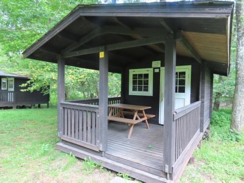 a wooden cabin with a picnic table on a deck at -be- Kita Karuizawa Camp Field - Vacation STAY 42270v in Kita-karuizawa